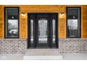 Black front door with glass accents and sidelights, set against a wood and brick exterior at 2101 N Wolf Cv, Martinsville, IN 46151