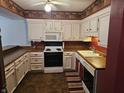 Galley kitchen with white cabinets, wood countertops, and dark flooring at 14 Winchester Ct, Anderson, IN 46013