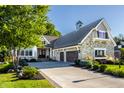 Beautiful home with a stone facade, a well-kept lawn, and a spacious three car garage at 340 Beechwood Farm Ln, Indianapolis, IN 46260