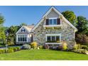 Charming stone-faced house with a well-manicured lawn and beautiful landscaping at 340 Beechwood Farm Ln, Indianapolis, IN 46260