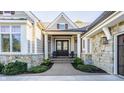 Inviting front porch with double doors, stone accents, and manicured landscaping at 340 Beechwood Farm Ln, Indianapolis, IN 46260