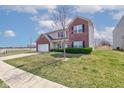 View of the home from the sidewalk; two-story home with brick accents and a well-maintained lawn at 11851 Fawn Crest Dr, Indianapolis, IN 46235