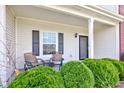 Charming front porch with seating, decorative shrubs, and a view of the house number at 11851 Fawn Crest Dr, Indianapolis, IN 46235