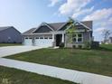 Gray brick house with a 3-car garage and sidewalk at 7834 Fairwood Blvd, Plainfield, IN 46168