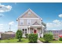 Charming two-story home featuring a well-maintained lawn, lovely landscaping, and a welcoming red front door at 2434 N Pennsylvania St, Indianapolis, IN 46205