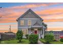 Charming two-story home featuring a well-maintained lawn, lovely landscaping, and a welcoming red front door at 2434 N Pennsylvania St, Indianapolis, IN 46205