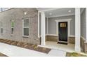 Inviting covered front porch features gray brick and tiled walls and a white door at 5743 Cr W 750 N, McCordsville, IN 46055