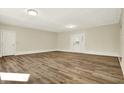Spacious living room featuring wood-look flooring, fresh neutral paint, and ample natural light from the door at 7635 Grizzly Dr, Nineveh, IN 46164