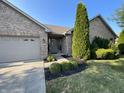 Brick home's front entrance with 2-car garage and landscaping at 1144 Woodridge, Brownsburg, IN 46112