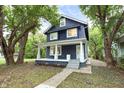 Inviting two-story home with mature trees, a classic front porch, and manicured landscaping at 3031 N New Jersey St, Indianapolis, IN 46205
