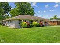Picture of home's exterior featuring lush lawn, colorful shrubs, and a one-car attached garage on a sunny day at 105 Tulip Dr, Indianapolis, IN 46227
