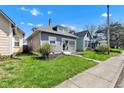 Side view of charming bungalow-style home with a well-maintained lawn and sidewalk at 2137 Ringgold Ave, Indianapolis, IN 46203