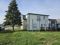 View of the backyard with a chain link fence, a deck, and mature trees at 902 W Main St, Greenfield, IN 46140