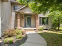 Inviting front entrance features a curved sidewalk and landscaped garden with mature shrubs and flowering plants at 1936 Broadmoor Ln, Columbus, IN 47203