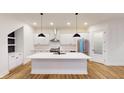 Modern white kitchen with large island and stainless steel appliances at 9870 Bucklebury Ln, Carmel, IN 46280