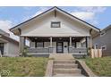 Charming two-story home featuring a covered porch and professionally landscaped front yard at 1210 Finley Ave, Indianapolis, IN 46203