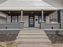 Inviting covered front porch with wood ceiling, brick columns and sitting area at 1210 Finley Ave, Indianapolis, IN 46203