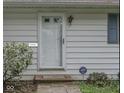 Close-up of a white front door with sidelights and a security system sign, set against light-colored siding at 9634 Maple Dr, Carmel, IN 46280