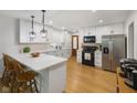 Modern kitchen with white cabinets, stainless steel appliances, quartz countertops, and hardwood floors at 236 Bixler Rd, Indianapolis, IN 46227