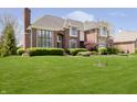 Beautiful brick home with a well-maintained lawn and mature trees at 13668 Cheswick Blvd, Carmel, IN 46032