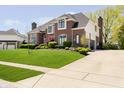 Charming brick house with green lawn, landscape, and driveway at 13668 Cheswick Blvd, Carmel, IN 46032