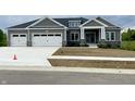 Charming single-story home with gray siding, stone accents, and a three-car garage at 3725 Maple Ridge Trl, Columbus, IN 47201