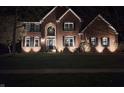 Inviting brick home at night with landscape lighting enhancing its architectural features at 14626 Warner Trl, Westfield, IN 46074