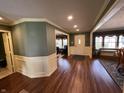 Open-concept living room featuring hardwood floors, neutral paint, and decorative moldings throughout the area at 5656 Buck Dr, Noblesville, IN 46062