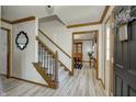 Entryway with wood trim staircase, luxury vinyl plank flooring, and a view of the dining room at 1487 Brook Mill Ct, Carmel, IN 46032