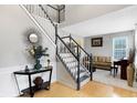 Bright entryway with hardwood floors, staircase, and views to living room at 11419 Romeo Pl, Fishers, IN 46040