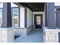 Front entrance with stonework, dark-stained columns, and a black door at 18862 Shefler Blvd, Noblesville, IN 46062
