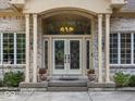Elegant front entry with chandelier, sidelights, and decorative planters at 9943 Irishman'S Run Ln, Zionsville, IN 46077
