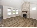 Spacious living room featuring a stone fireplace, large windows and beautiful floors at 4982 Reavie Ct, Noblesville, IN 46062