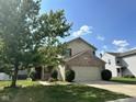 Traditional two-story home features an attached two car garage and front yard landscaping at 1946 Central Park W Blvd, Greenwood, IN 46143