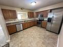 Spacious kitchen with stainless steel appliances, wooden cabinets, and tile floors at 1946 Central Park W Blvd, Greenwood, IN 46143