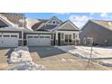 Attractive gray home with a two-car garage and stone accents; snow-covered front yard at 16920 Cattle Hollow Ln, Noblesville, IN 46060
