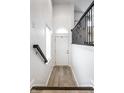 Bright hallway with wood floors, white walls, black handrail, and a window at 729 Greenford N Trl, Carmel, IN 46032