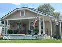 Inviting single story home with a covered front porch, plants, and an American flag at 217 Ringwood Way, Anderson, IN 46013