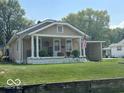 Charming single story home with a covered front porch, lawn, and an American flag at 217 Ringwood Way, Anderson, IN 46013
