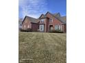 Traditional brick home featuring well-maintained lawn, trimmed shrubs and architectural details at 10870 Picket Fence Pl, Fishers, IN 46037