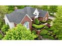 Lovely aerial view of a brick home surrounded by beautiful landscaping and mature trees at 2838 Silverwood Ln, Greenwood, IN 46143
