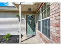 Inviting front entrance with a charming teal door, brick accents, and decorative details creating a warm and welcoming ambiance at 828 Ashton Park Dr, Greenwood, IN 46143