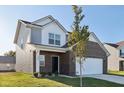 Two-story home with gray and brick exterior, and a tree in front at 222 Winding Brook Way, Pendleton, IN 46064