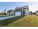 Side view of a two-story home showcasing brick exterior and a garage at 222 Winding Brook Way, Pendleton, IN 46064
