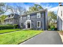 Charming two-story home with a brick facade, black shutters, manicured lawn, and inviting walkway at 22 W 54Th St, Indianapolis, IN 46208