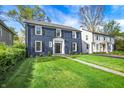 Charming two-story home with a brick facade, black shutters, manicured lawn, and inviting walkway at 22 W 54Th St, Indianapolis, IN 46208