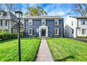 Charming two-story home with a brick facade, black shutters, manicured lawn, and inviting walkway at 22 W 54Th St, Indianapolis, IN 46208