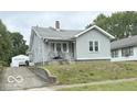 View of a quaint single-Gathering home with light gray siding and a detached garage at 240 W 37Th St, Anderson, IN 46013