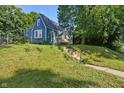Charming blue home with lovely flower boxes on the porch and a manicured lawn and sidewalk at 327 Central Ave, Anderson, IN 46012