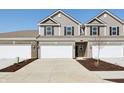 Townhome showcasing neutral siding, a two-car garage, and tasteful front yard landscaping at 6286 Wasco Dr, Whitestown, IN 46075